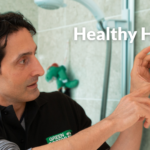 Tahir, a Green Doctor in London, fitting an energy saving measure in a shower